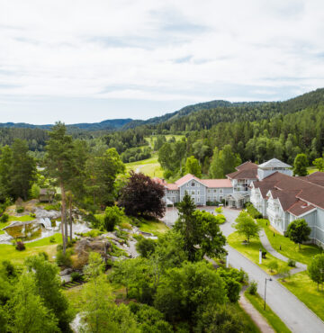 Flyfoto av Losby Gods hotel. Omringet av Østmarkas skoger.
